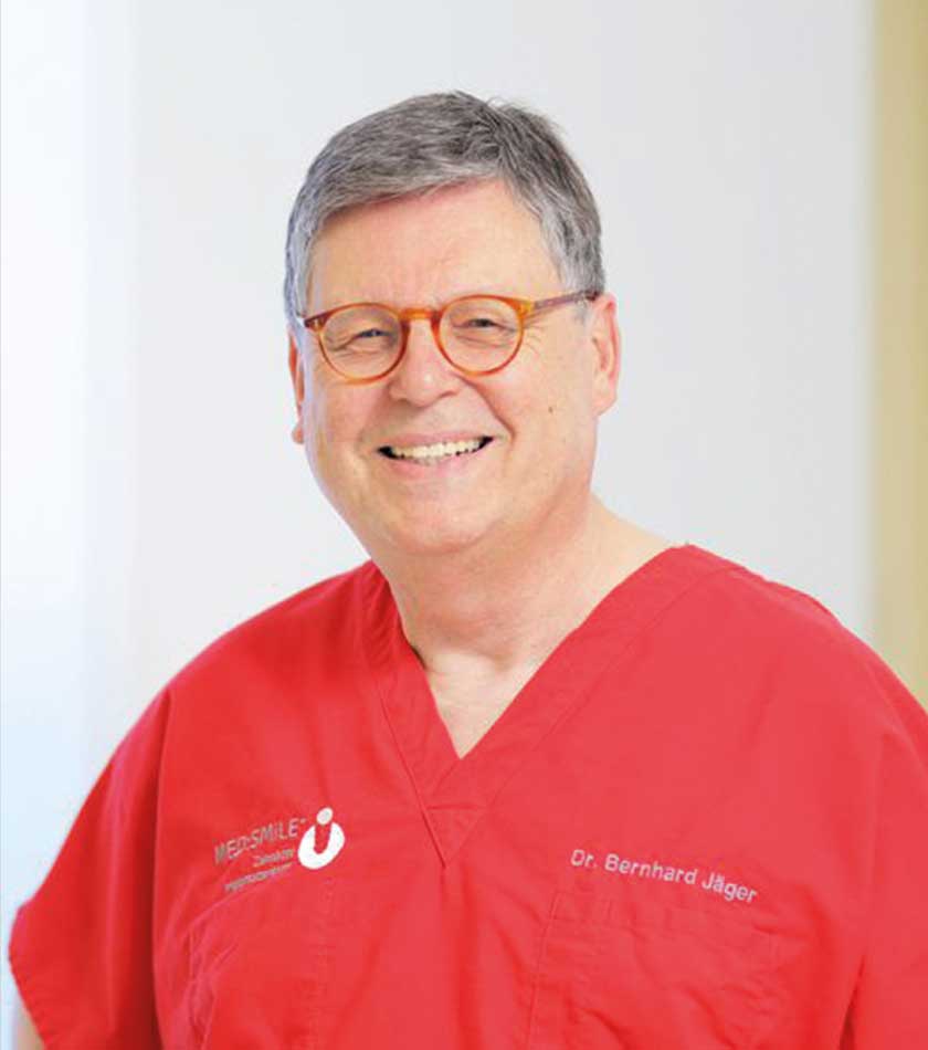 Dr. Bernhard Jäger mit rotem Schlupfkasack mit MED:SMILE-Logo 