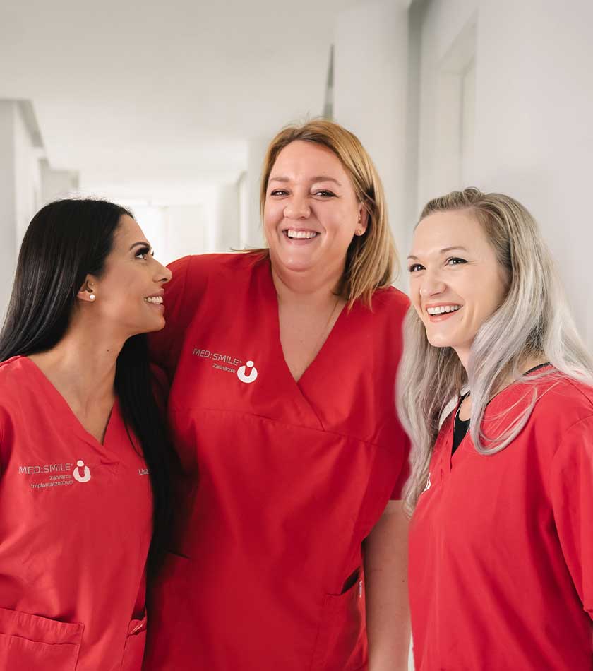 Drei lächelnde Mitarbeiterinnen von MED:SMILE im Gespräch