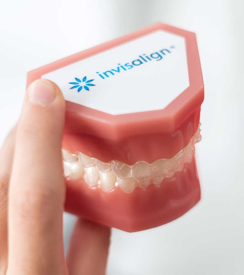Gebissmodell mit Invisalign-Logo mit transparenten Zahnschienen