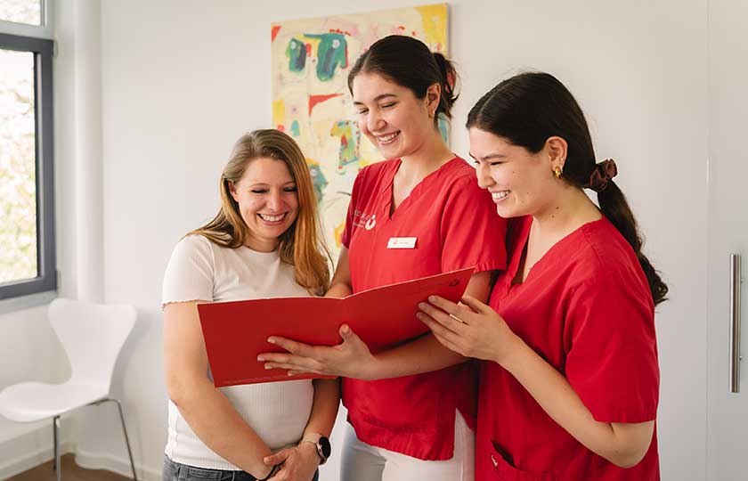 Zwei ZFA von MED:SMILE im Gespräch mit einer Patientin