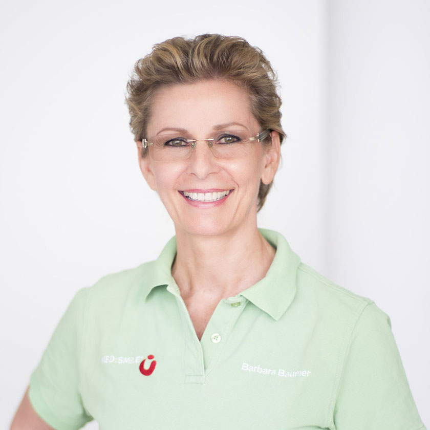 MED:SMILE-Teammitglied Barbara B. in grünem Polohemd mit MED:SMILE-Logo und Namensaufdruck.